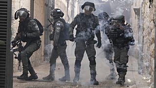 Palestinos disparan fuegos artificiales a la policía israelí en la Ciudad Vieja de Jerusalén, el 17 de abril de 2022.