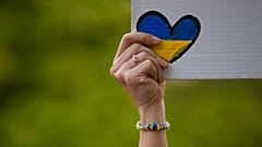 Une personne brandissant un cœur aux couleurs de l'Ukraine lors d'une manifestation devant l'ambassade russe à Bucarest, en Roumanie, le 16 avril 2022 