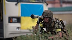 A Ukrainian government looks through a telescopic sight while guarding the positions in village Mariinka near Donetsk, eastern Ukraine, Aug. 11, 2014.