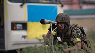 A Ukrainian government looks through a telescopic sight while guarding the positions in village Mariinka near Donetsk, eastern Ukraine, Aug. 11, 2014.