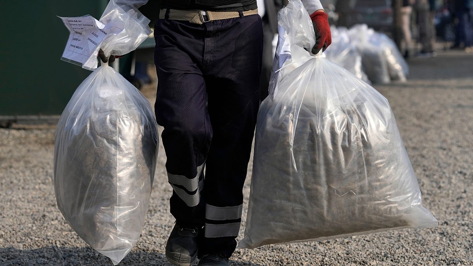 Kábítószerégetéshez cipelik a zsákokat Peruban, Limában, 2022. április 18-án