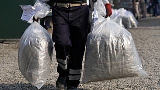 Kábítószerégetéshez cipelik a zsákokat Peruban, Limában, 2022. április 18-án