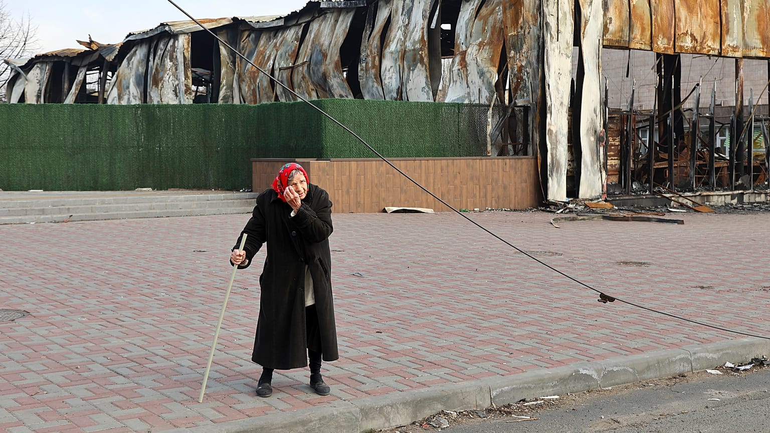 Пожилая женщина у разрушенного цеха Металлургического комбината им. Ильича