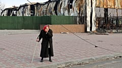 Пожилая женщина у разрушенного цеха Металлургического комбината им. Ильича