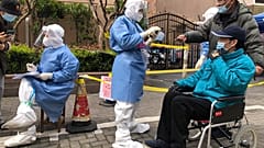 FILE - Workers in protective gear register residents for COVID testing in the Jingan district of western Shanghai, China, Friday, April 1, 2022