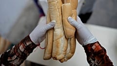 Una mujer reparte pan a la gente en un comedor social en Buenos Aires, Argentina, el martes 19 de abril de 2022. 