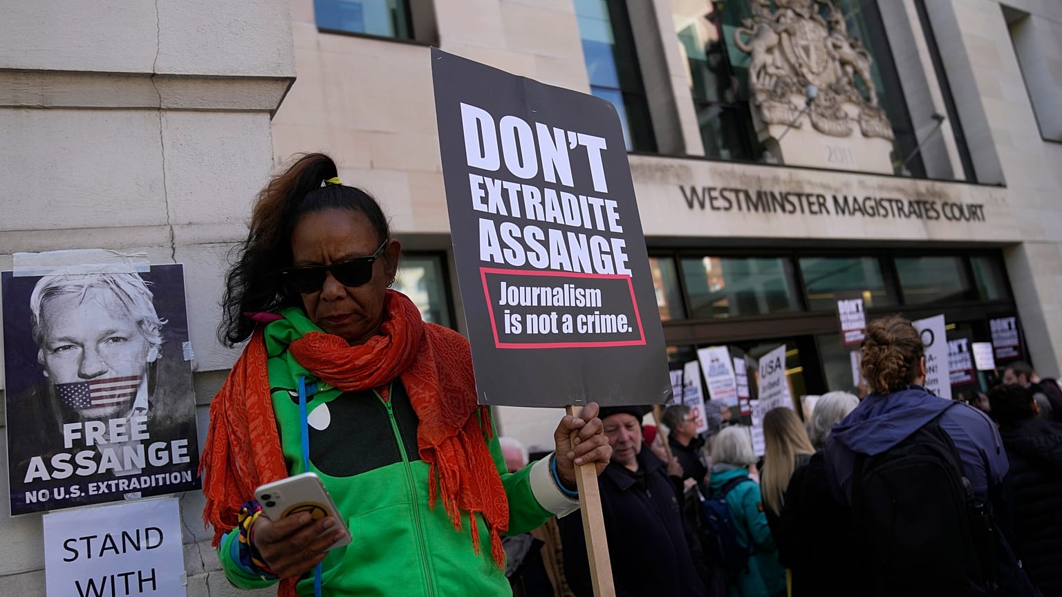 Wikileaks founder Julian Assange supporters hold placards as they gather outside Westminster Magistrates court In London, Wednesday, April 20, 2022