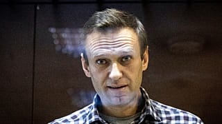 Russian opposition leader Alexei Navalny looks at photographers standing in the Babuskinsky District Court in Moscow, Russia, Saturday, Feb. 20, 2021.