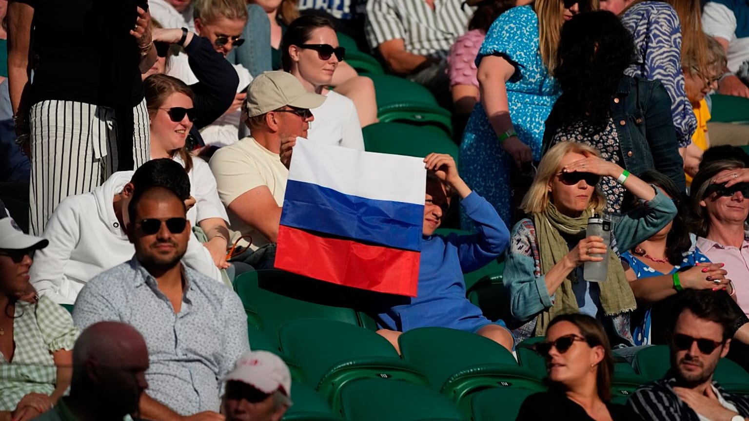 A spectator holding a Russian flag watches during the 2021 Wimbledon Tennis Championships in London.