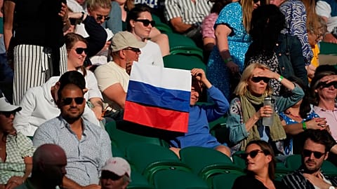 A spectator holding a Russian flag watches during the 2021 Wimbledon Tennis Championships in London.