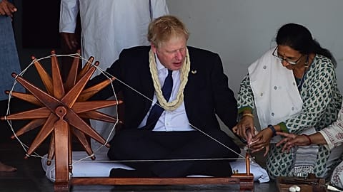 Prime Minister Boris Johnson tries to spin a cotton thread