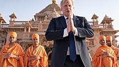 Boris Johnson walks with sadhus, Hindu holymen, as he visits the Swaminarayan Akshardham temple in Gandhinagar, Ahmedabad, part of his two-day trip to India, April 21, 2022.