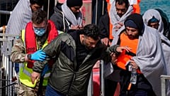 أفراد من حرس الحدود البريطانيين ينقلون مجموعة من المهاجرين بميناء دوفر، 14 نيسان/أبريل، 2022