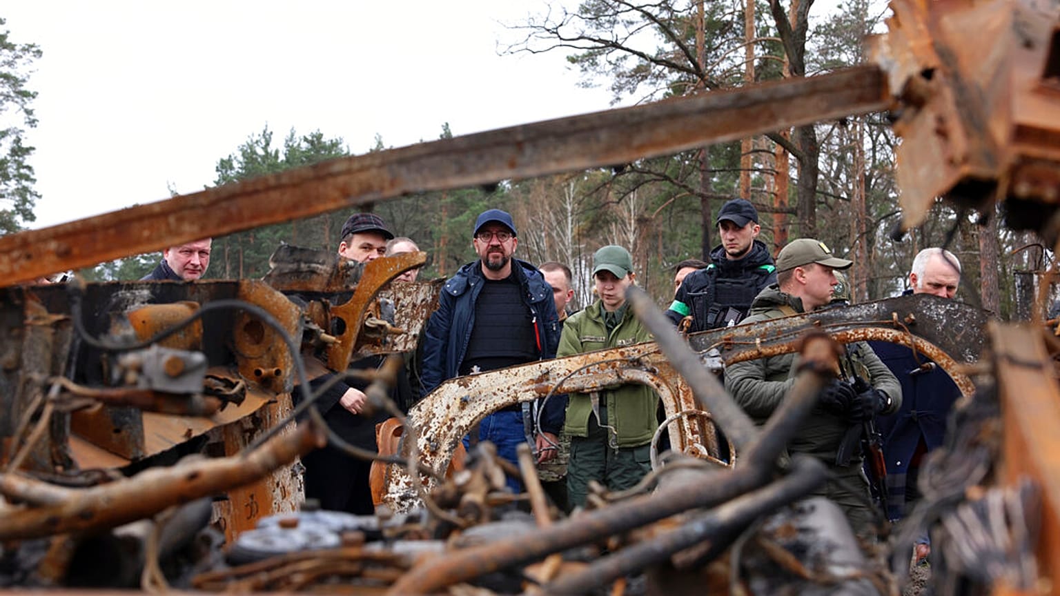 European Council President Charles Michel, center, looks at destroyed vehicles as he is given a tour of the region of Borodyanka, Ukraine, April 20, 2022. 