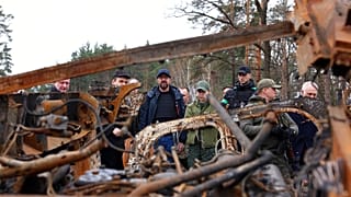 European Council President Charles Michel, center, looks at destroyed vehicles as he is given a tour of the region of Borodyanka, Ukraine, April 20, 2022.