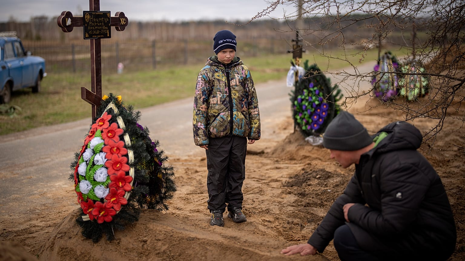 Десятилетний мальчик на похоронах своей матери, погибшей в Буче во время оккупации.