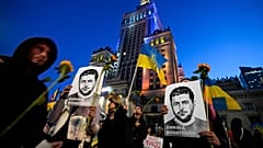 Activist holds portraits of Ukrainian President Volodymyr Zelenskyy during a protest demanding an energy embargo to Russia and the stop of the war in Warsaw, 22 April 2022