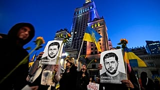 Activist holds portraits of Ukrainian President Volodymyr Zelenskyy during a protest demanding an energy embargo to Russia and the stop of the war in Warsaw, 22 April 2022