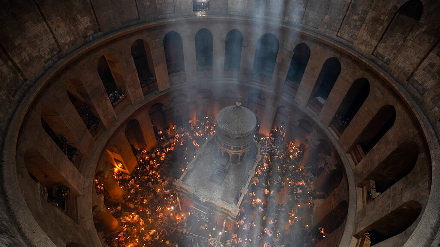 Keresztény zarándokok gyertyát tartanak a Szent Sír-templomban a Szent Tűz szertartásán