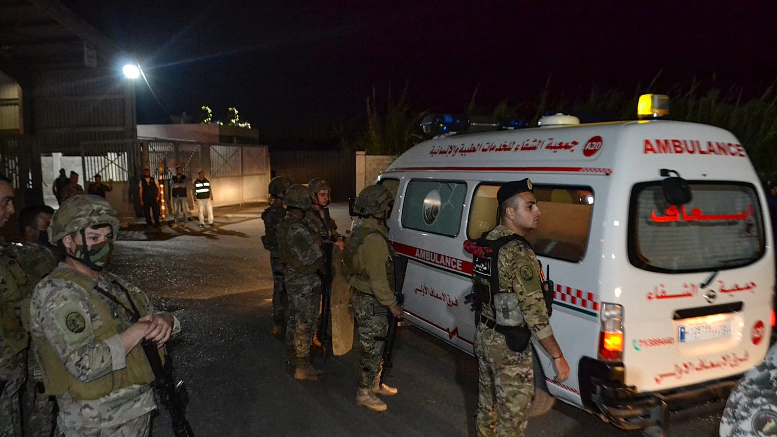 Libanesische Soldaten wachen am Eingang des Hafens von Tripoli während Krankenwagen Opfer des Bootsungklücks abtransportieren.