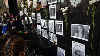 Flores en la fachada de la Procuraduría General de la República rodean imágenes de Debanhi Escobar, y otras mujeres desaparecidas,22/4/2022, Ciudad de México, México