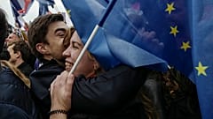 Anhänger:innen des französischen Präsidenten mit EU-Flagge warten auf seine Rede am Wahlabend in Paris