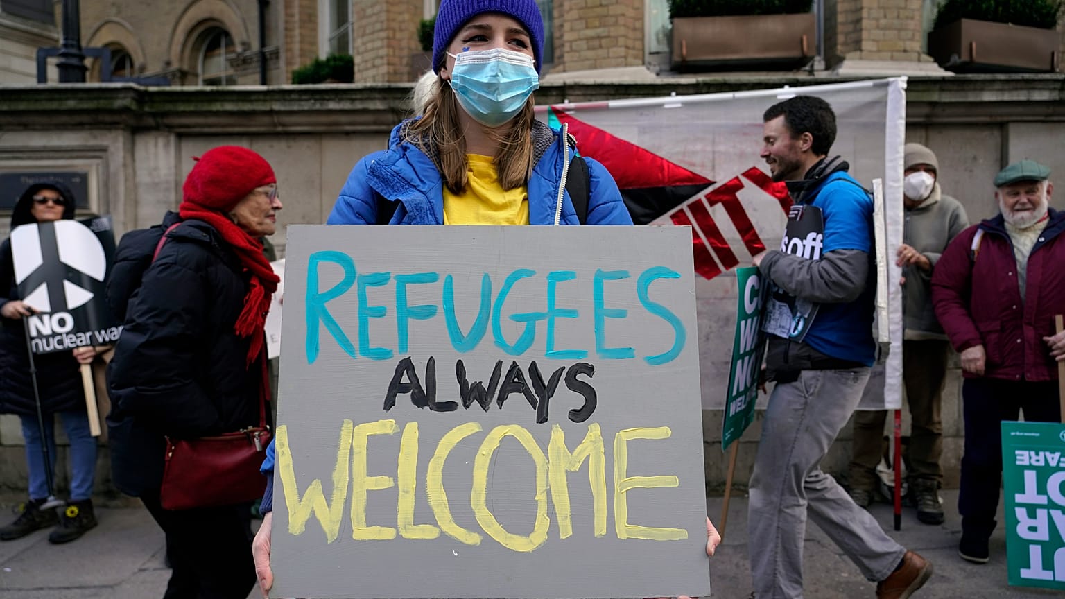 A demonstrator holds a placard saying 'Refugees always welcome' during an anti-war march, in London, Sunday, March 6, 2022. 
