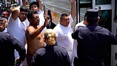 الأشخاص الذين تم القبض عليهم بزعم صلاتهم بالعصابة ترافقهم الشرطة المدنية الوطنية في مركز العقوبات في سان سلفادور، 25 أبريل 2022