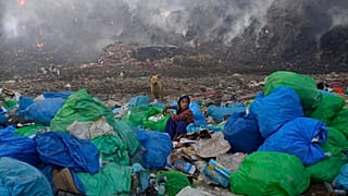 Müllsammlerin an der brennenden Kippe Bhalswa in Neu-Delhi.