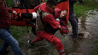 Des secouristes ukrainiens portent assistance à une victime d'un bombardement russe à Kharkiv (Ukraine), le 27/04/2022