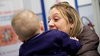 Luana Monoclesi, tient son bébé de 8 mois dans un centre de vaccination à Rome, le 23 février 2018, 