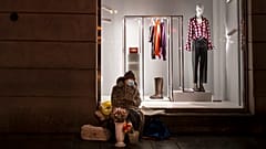A woman wearing a face mask to protect against coronavirus, sells flowers on a warm winter evening at a Gediminas Avenue in Vilnius
