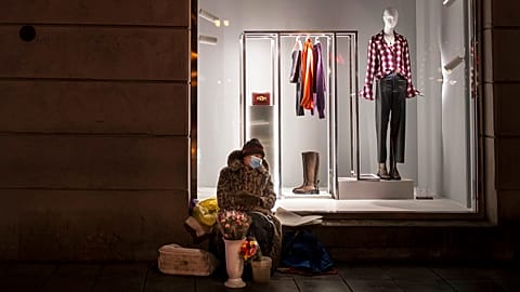 A woman wearing a face mask to protect against coronavirus, sells flowers on a warm winter evening at a Gediminas Avenue in Vilnius