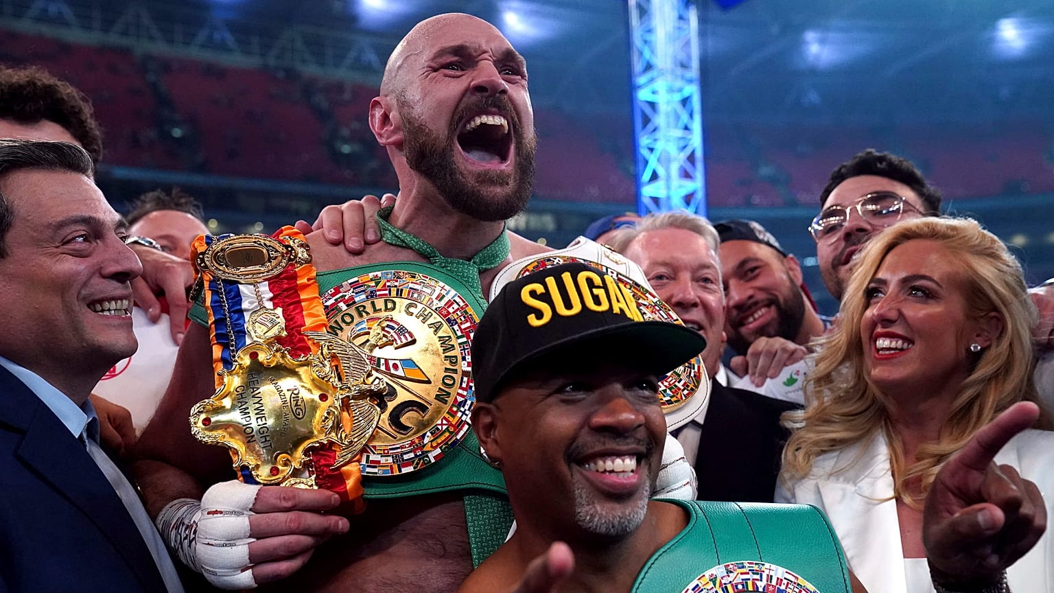 Tyson Fury (középen felül) a feleségével (jobbra) ünnepel, miután kiütötte Dillian Whyte-ot a londoni Wembley Stadionban 2022. április 23-án.