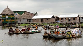 Vendors display their goods in pirogues at a floating market in Ganvie, Benin.