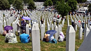 صورة من الارشيف- أفراد عائلات ضحايا مجزرة سريبرينيتشا يتجمعون قبل مراسم دفن توابيت مع رفات أقاربهم في المقبرة التذكارية في قرية بوتوكاري، بالقرب من بلدة سريبرينيتشا