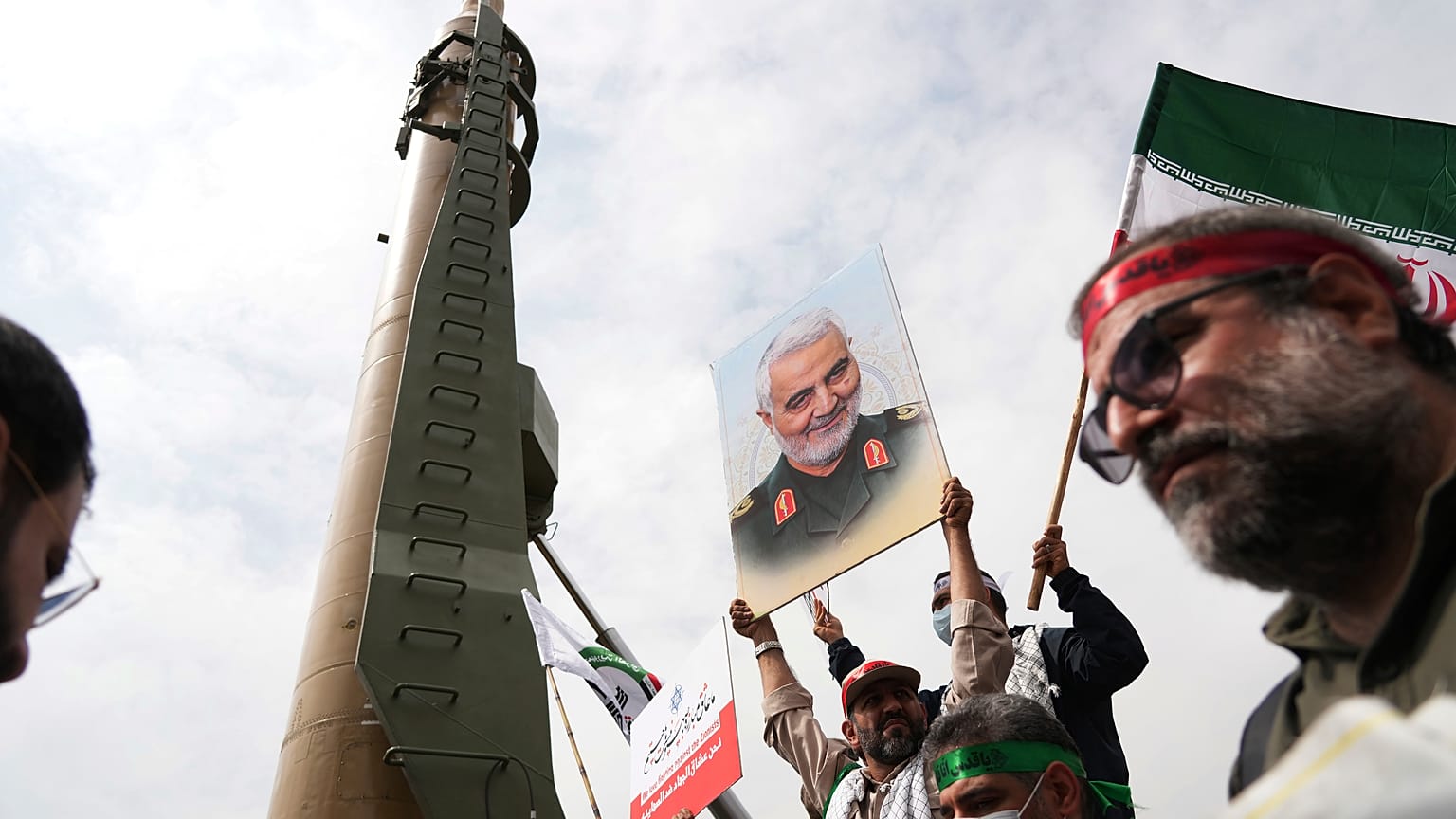 متظاهرون في طهران بمناسبة "يوم القدس" يقفون قرب صاروخ "شهاب3" 
