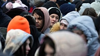 Refugees from Ukraine wait in a crowd for transportation after fleeing their homeland and arriving at the border crossing in Medyka, Poland, Monday, 7 March, 2022
