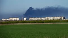 In der Ferne steigt über dem umkämpften Stahlwerk in Mariupol Rauch auf.