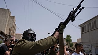 مقاتل فلسطيني ملثم يطلق النار في الهواء خلال جنازة يحيى عدوان في قرية عزون بالضفة الغربية، بالقرب من قلقيلية. 2022/04/30