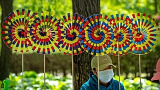Продавец в маске в одном из общественных парков Пекина, апрель 2022 г.