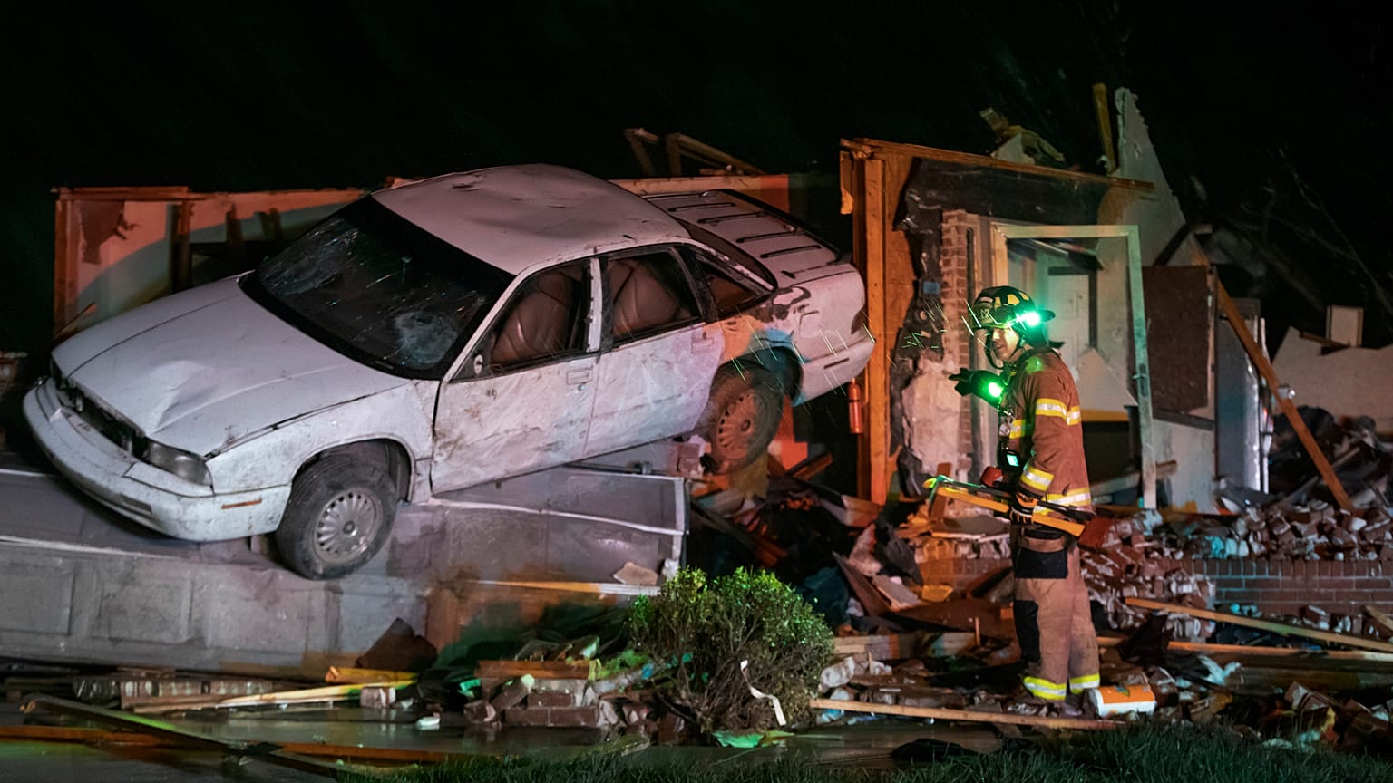 Firefighter searches a home in Andover, Kansas, after a tornado ripped through the area just east of Wichita.
