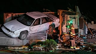 Firefighter searches a home in Andover, Kansas, after a tornado ripped through the area just east of Wichita.