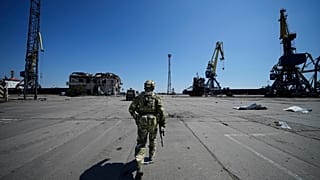 Un militar ruso camina mientras vigila una zona del puerto marítimo de Mariupol, en el este de Ucrania, el viernes 29 de abril de 2022