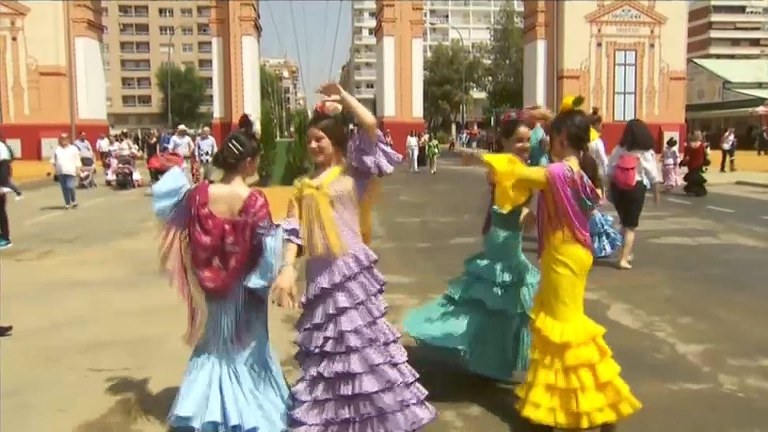Un grupo de chicas bailando delante de la portada ferial