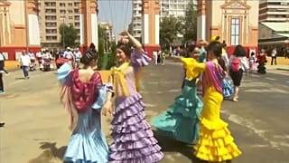 Un grupo de chicas bailando delante de la portada ferial