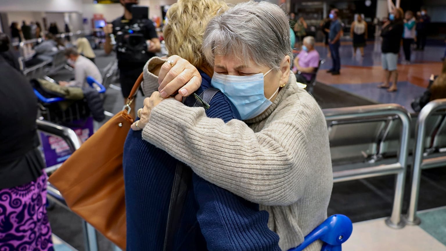 Families embrace after a flight from Los Angeles arrived at Auckland International Airport as New Zealand's border opened for visa-waiver countries Monday, May 2, 2022. 