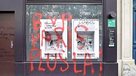 Grafitti über zerstörten Geldautomaten