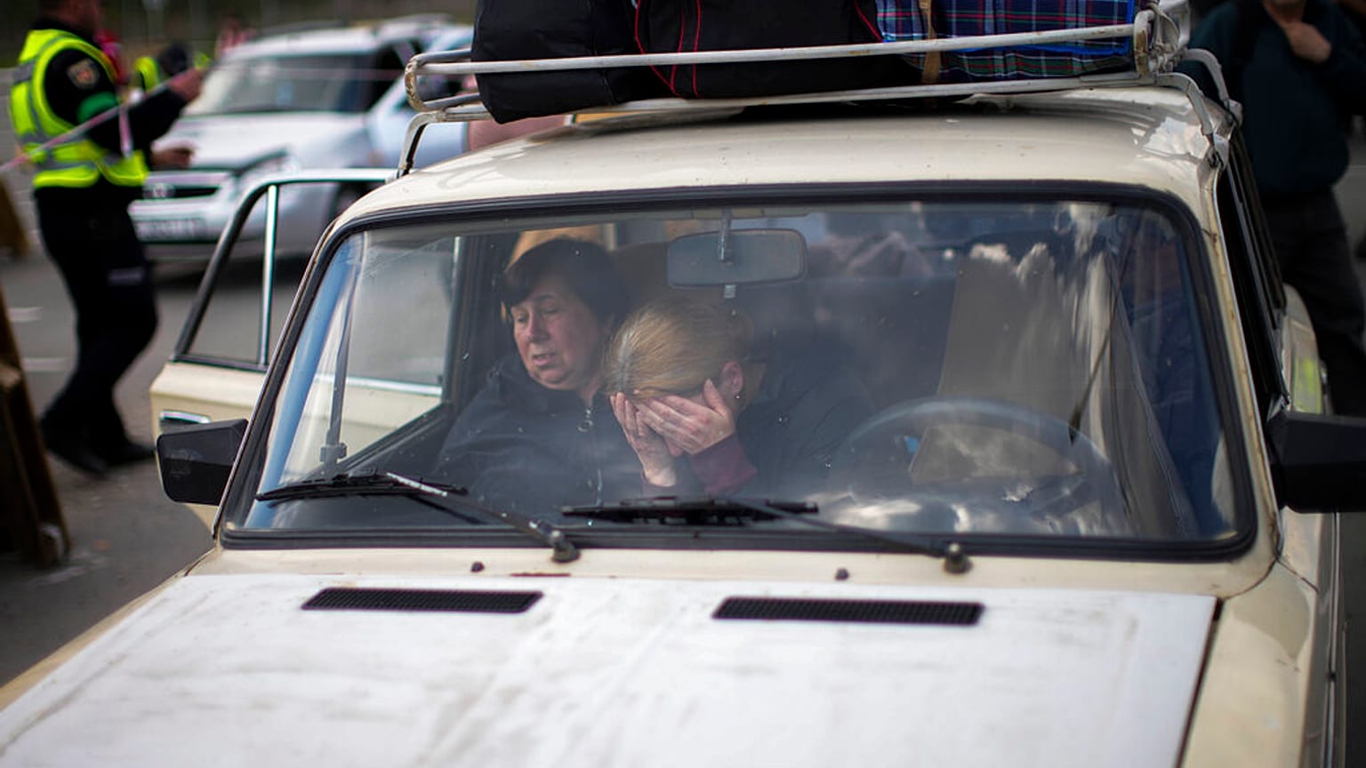 People wait in a car to be processed upon their arrival at a reception center for displaced people in Zaporizhzhia, Ukraine, Monday, May 2, 2022.