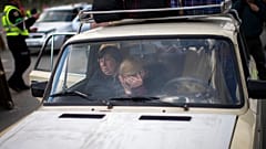 People wait in a car to be processed upon their arrival at a reception center for displaced people in Zaporizhzhia, Ukraine, Monday, May 2, 2022.